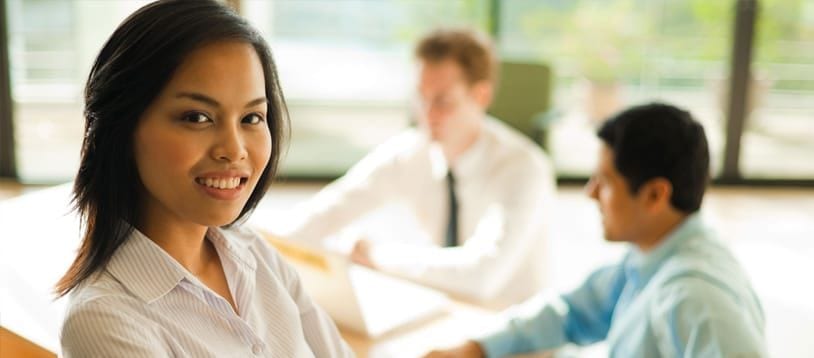 A young Asian woman is smiling and looking at the camera