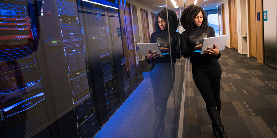 Woman leans against a server room