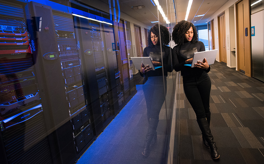 Woman leans against a server room